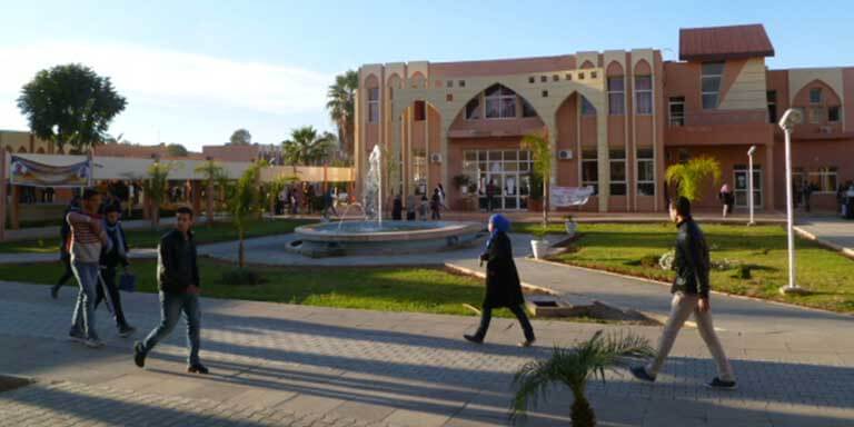 people walk around the UMI campus buildings
