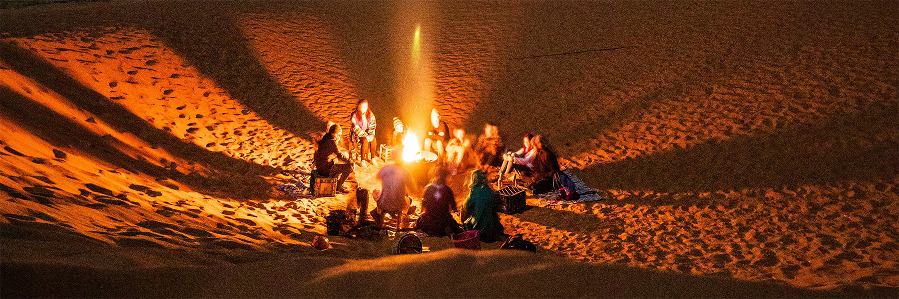 people around a campfire in the desert