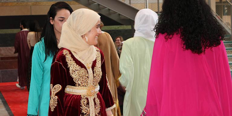 women smiling as they walk down fashion show catwalk