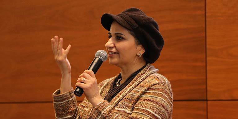 woman with hat on talking on microphone