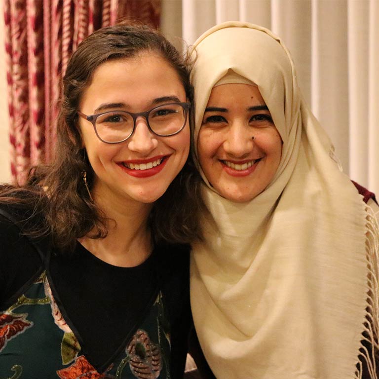 Two friends hug at the Arabic program dinner